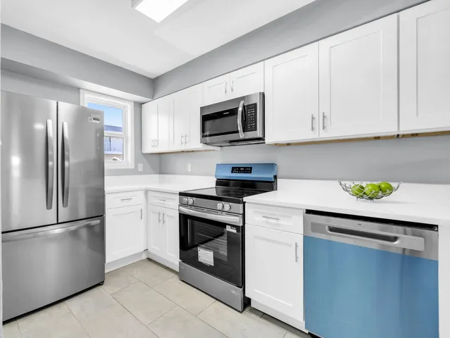 a kitchen with stainless steel appliances granite countertop a refrigerator a stove a sink and a microwave