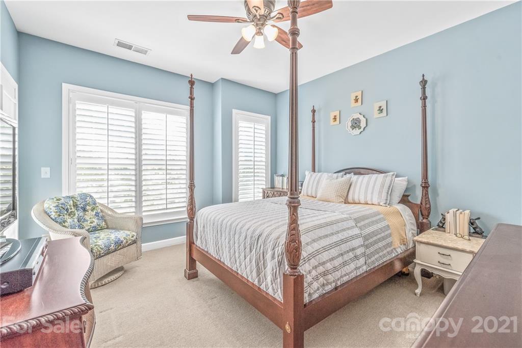 833 Millbrook Road, Unit 833 Charlotte, NC 28211 - Photo 14 of 23 a bedroom with a bed and a chandelier