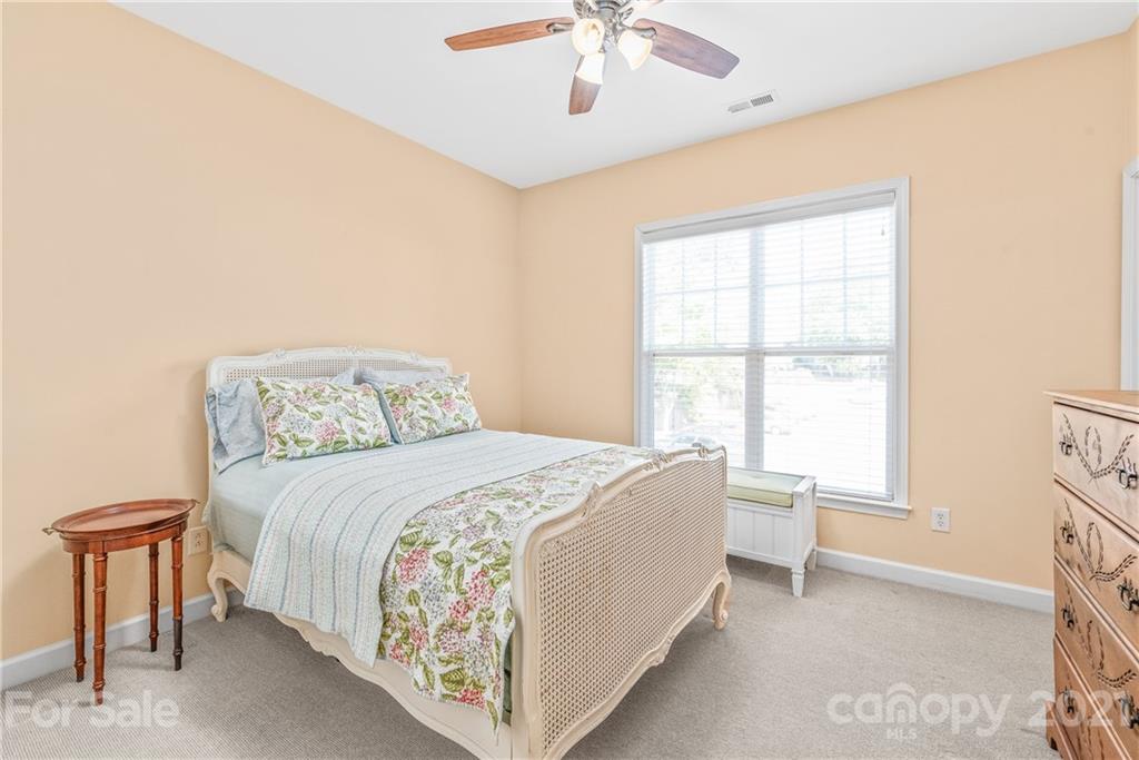 833 Millbrook Road, Unit 833 Charlotte, NC 28211 - Photo 17 of 23 a bedroom with a large bed and a chandelier fan