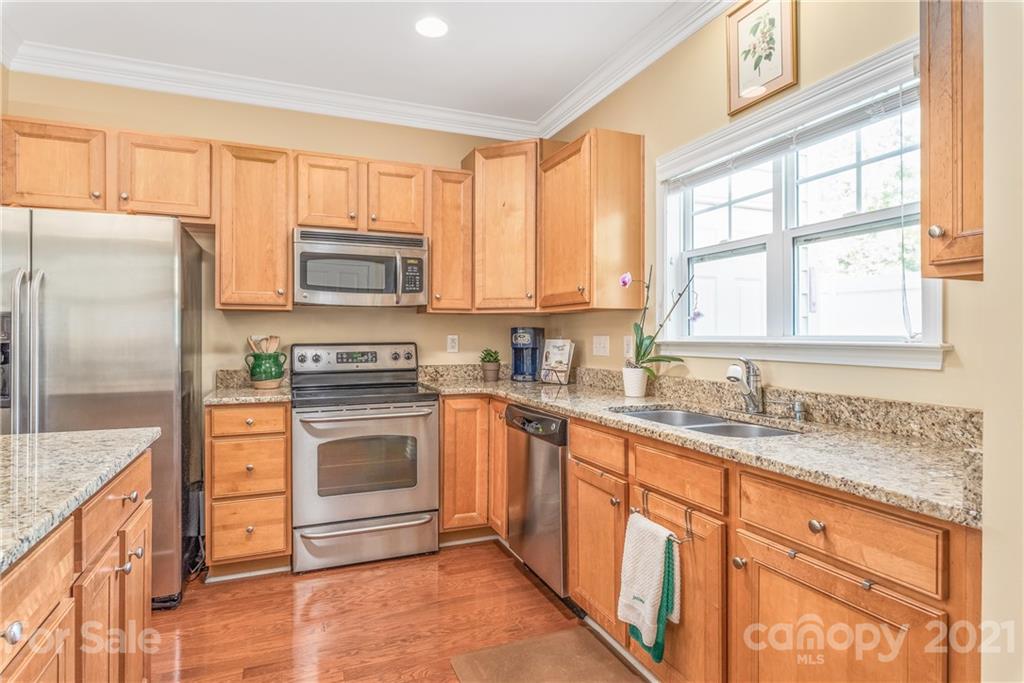 833 Millbrook Road, Unit 833 Charlotte, NC 28211 - Photo 8 of 23 a kitchen with granite countertop stainless steel appliances a stove sink and microwave