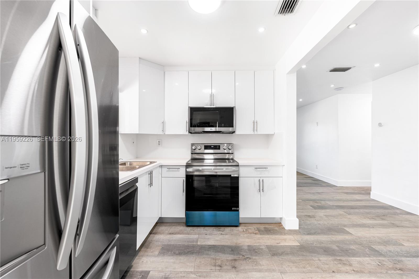 11970 Southwest 177th Terrace Miami, FL 33177 - Photo 13 of 47 a kitchen with stainless steel appliances a stove a microwave and a refrigerator