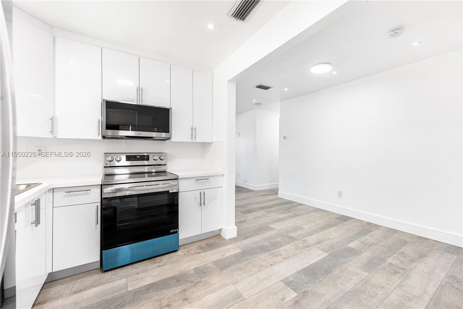 11970 Southwest 177th Terrace Miami, FL 33177 - Photo 14 of 47 a kitchen with granite countertop a stove and a microwave