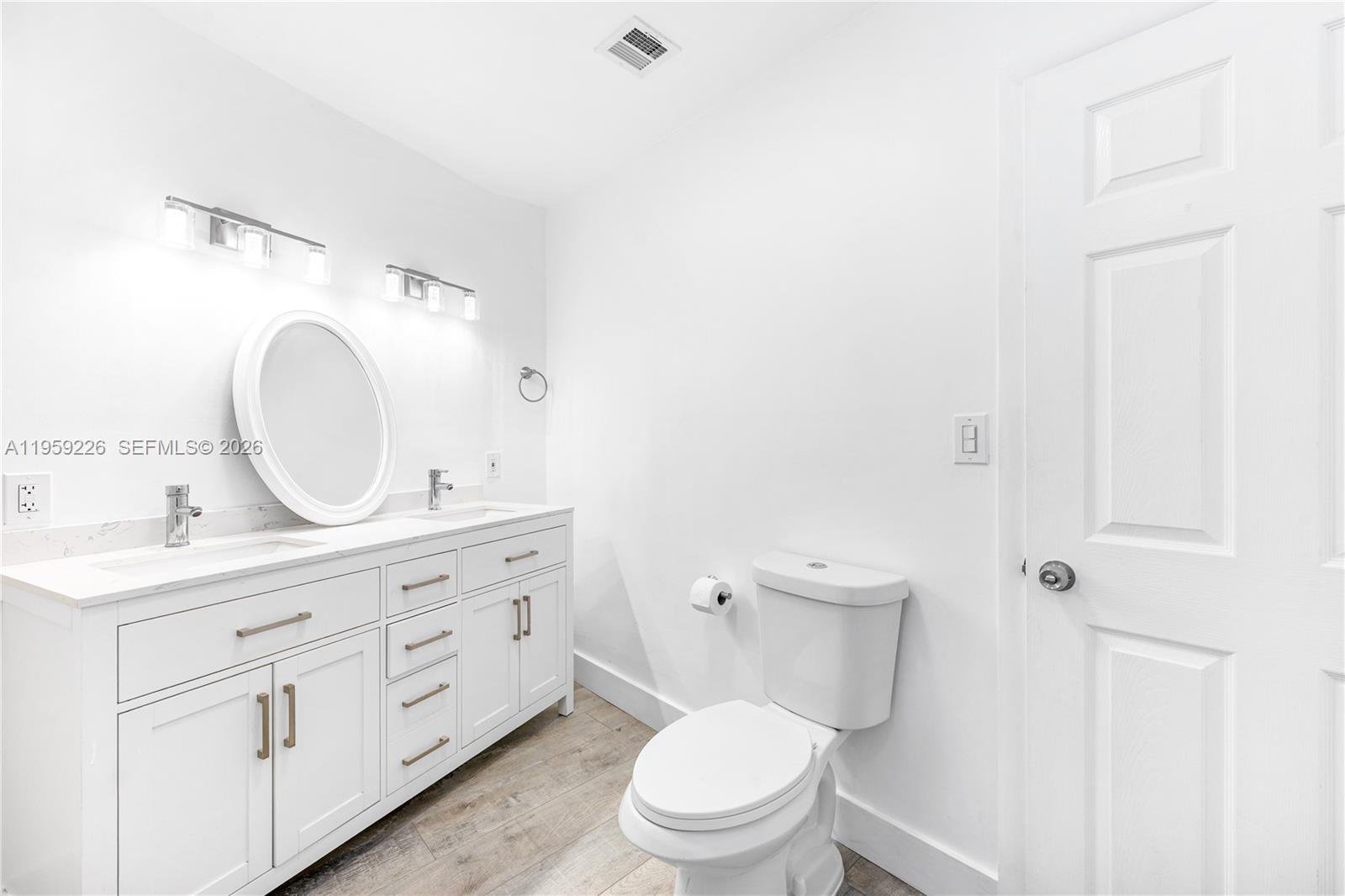 11970 Southwest 177th Terrace Miami, FL 33177 - Photo 20 of 47 a bathroom with a granite countertop toilet a double vanity sink and a mirror
