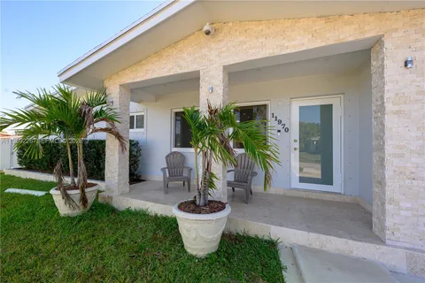 a view of a backyard with plants and palm tree