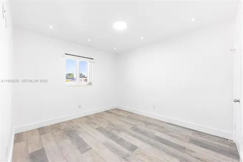 a view of a hallway with wooden floor and closet area