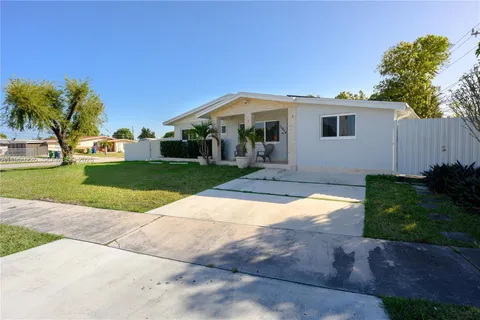 an aerial view of residential houses with outdoor space and parking
