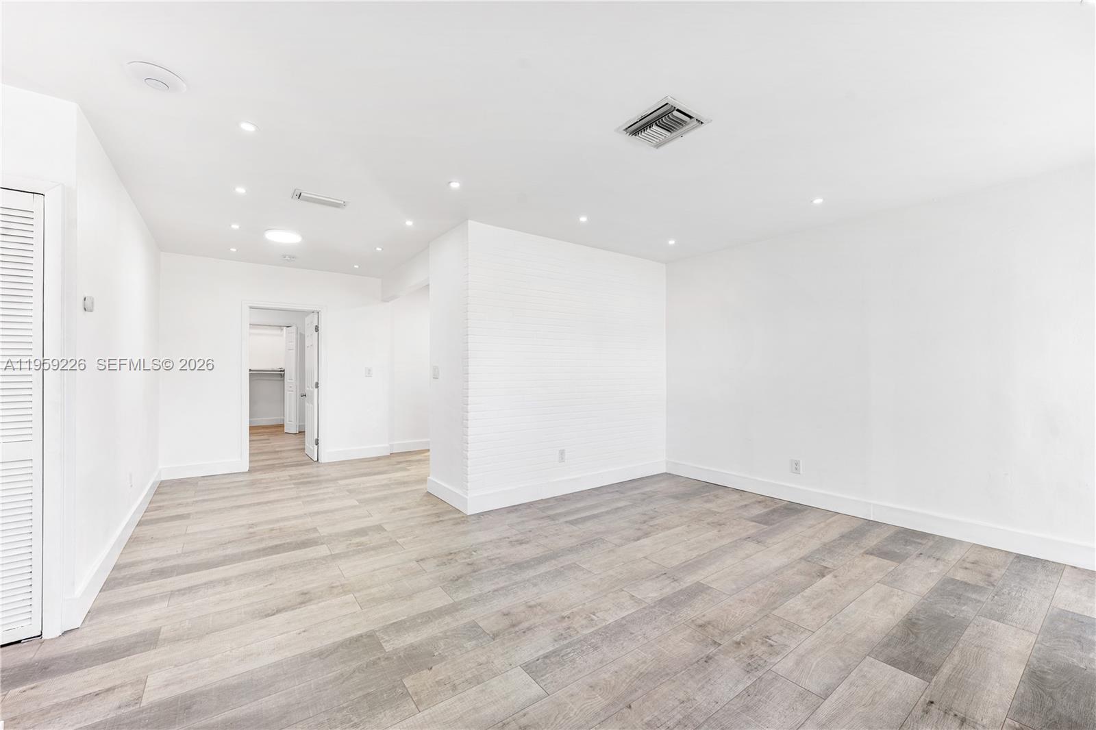 11970 Southwest 177th Terrace Miami, FL 33177 - Photo 8 of 47 an empty room with wooden floor and windows
