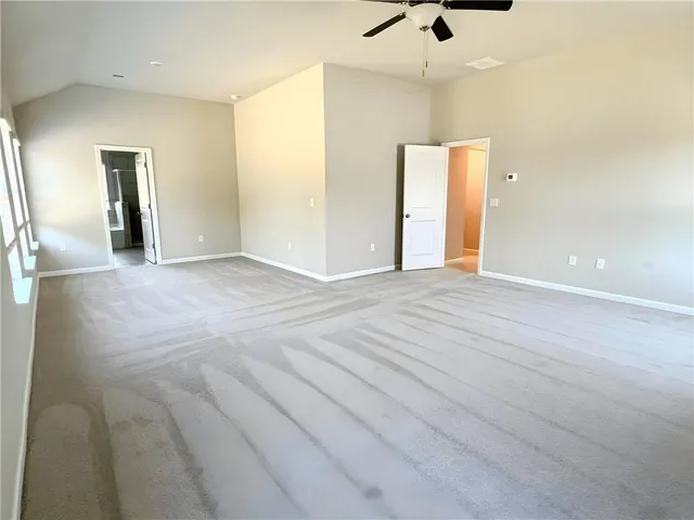 a view of an empty room with a ceiling fan