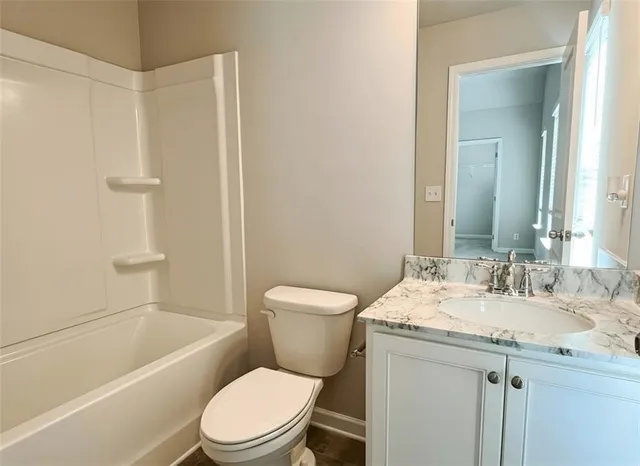 a bathroom with a granite countertop toilet a sink and a bathtub