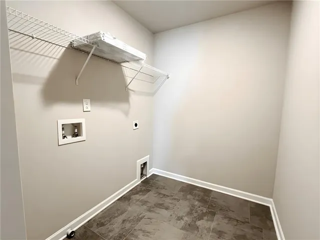 an empty room with a wooden door and a window