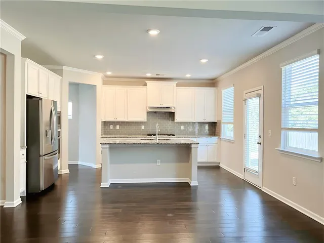 a kitchen with a refrigerator and white cabinets