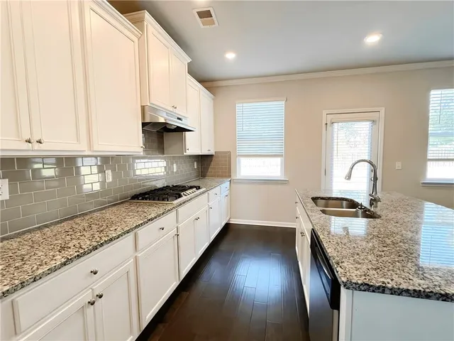 a kitchen with granite countertop lots of counter top space and wooden floor