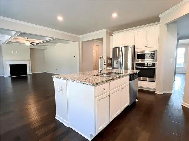 a kitchen with stainless steel appliances granite countertop a stove refrigerator and a stove