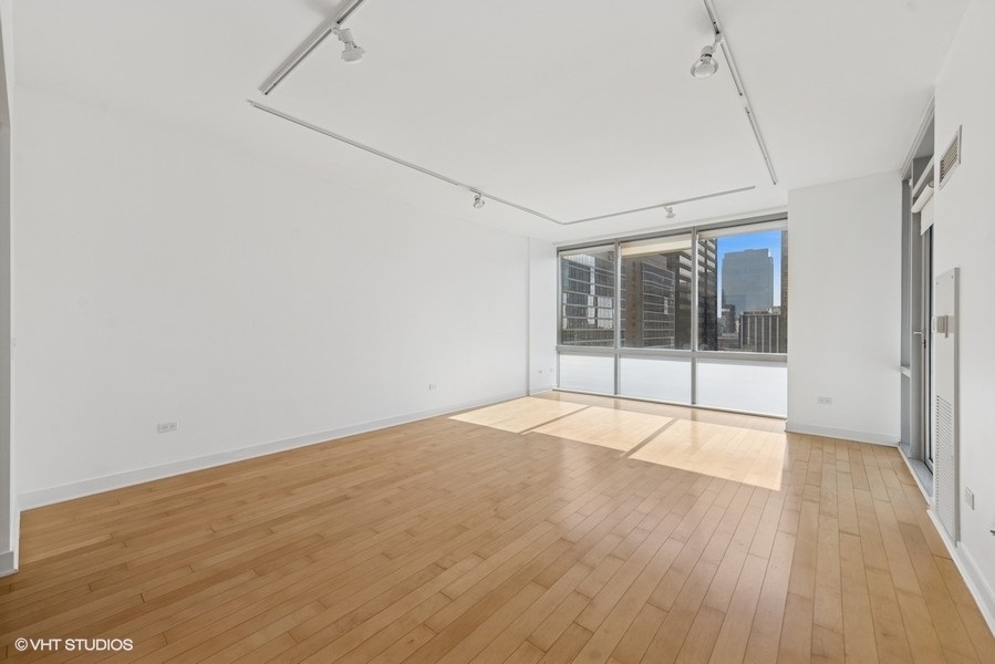 8 East Randolph Street, Unit 3007 Chicago, IL 60601 - Photo 3 of 15 an empty room with wooden floor and windows