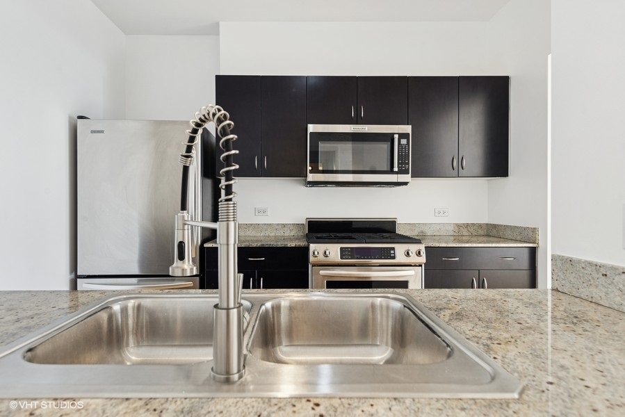 8 East Randolph Street, Unit 3007 Chicago, IL 60601 - Photo 7 of 15 a kitchen with stainless steel appliances kitchen island granite countertop a sink and a microwave