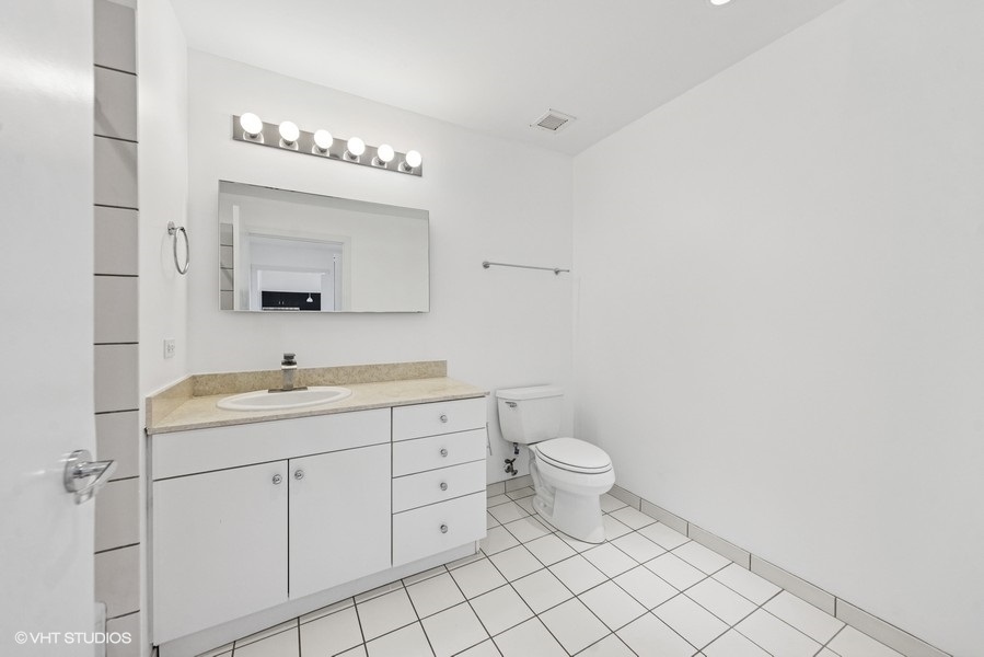 8 East Randolph Street, Unit 3007 Chicago, IL 60601 - Photo 10 of 15 a bathroom with a toilet a sink a mirror and vanity