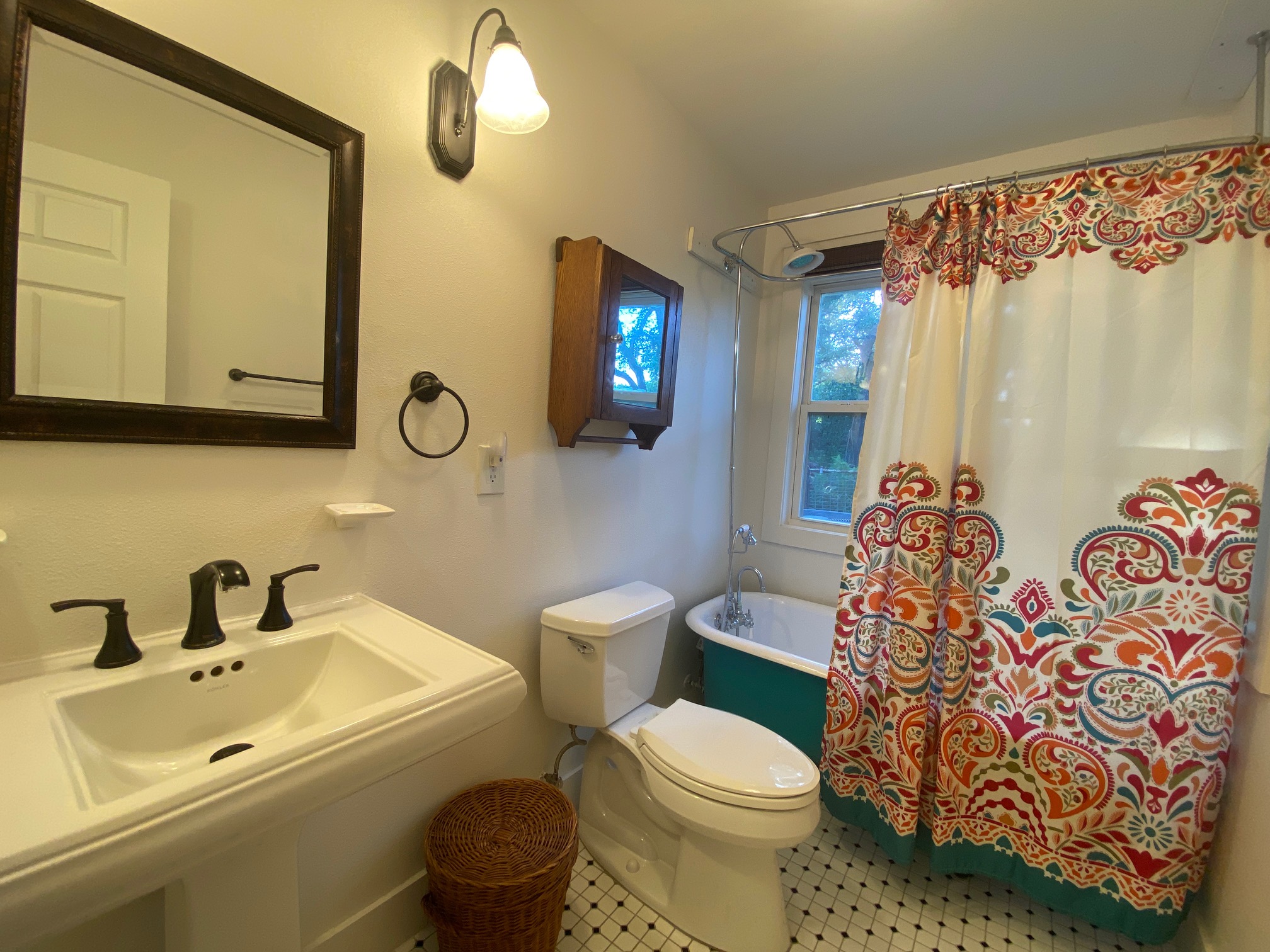 306 Plainview Road Wimberley, TX 78676 - Photo 18 of 29 A well-lit bathroom boasts a classic pedestal sink and a freestanding bathtub,