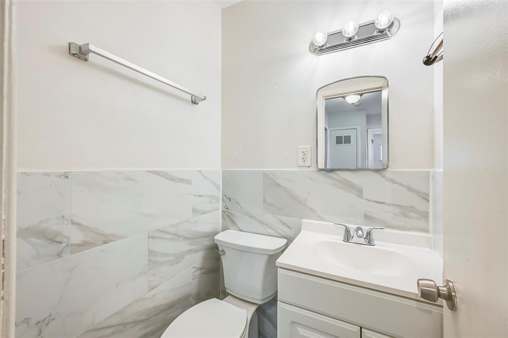 1905 South Cooper Street Arlington, TX 76010 - Photo 11 of 15 Bathroom featuring a white vanity with integrated sink, chrome faucet, and a wall-mounted mirror