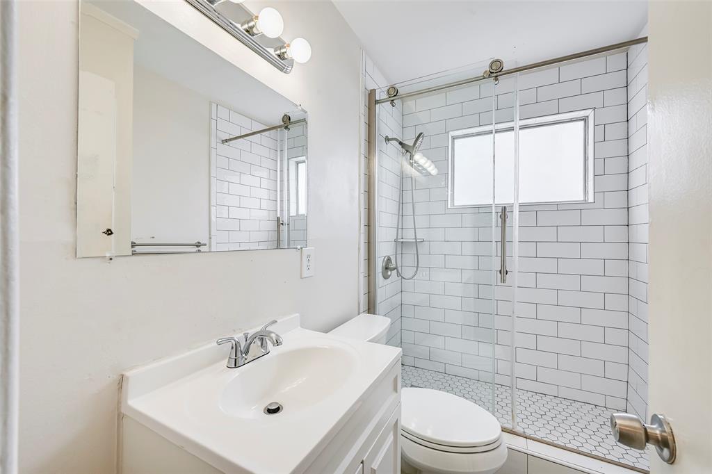 1905 South Cooper Street Arlington, TX 76010 - Photo 13 of 15 Bathroom featuring a single vanity, a chrome faucet, and a wall-mounted medicine cabinet