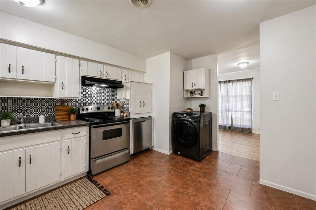 1905 South Cooper Street Arlington, TX 76010 - Photo 7 of 15 Kitchen featuring white cabinetry, dark countertops, a patterned tile backsplash, stainless steel appliances, and terra cotta-style floor tiles
