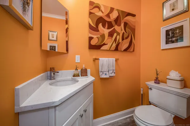 a kitchen with stainless steel appliances kitchen island granite countertop a refrigerator a stove and a wooden floors