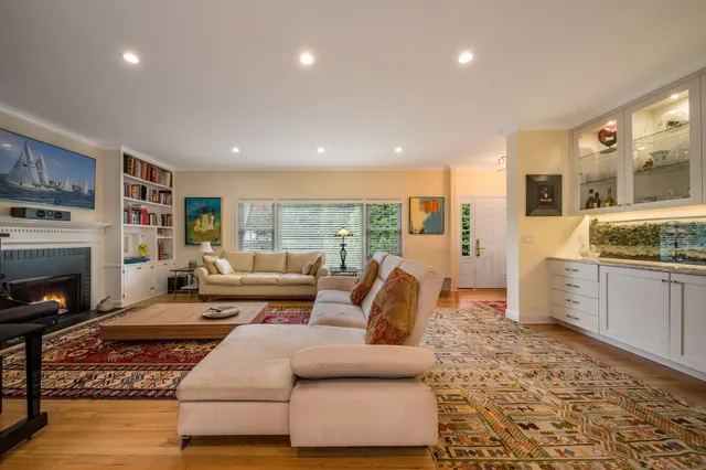 a living room with fish rug and a wooden floor