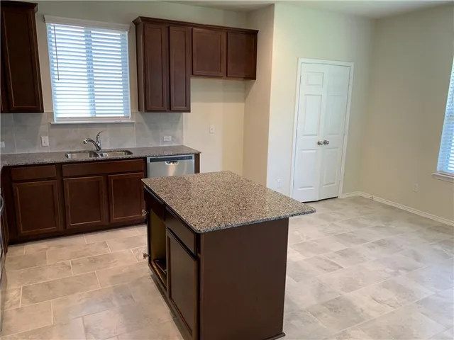 an empty room with kitchen view and a sink