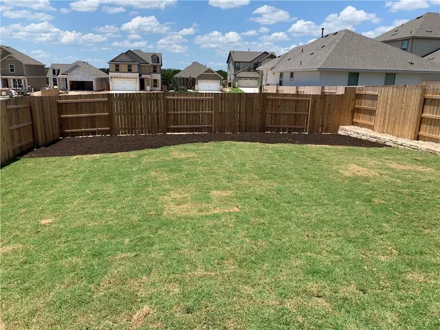 a view of a backyard with wooden fence