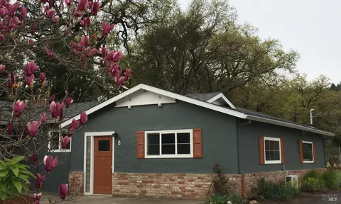 a front view of a house with a tree