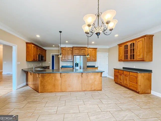 a large kitchen with stainless steel appliances granite countertop a sink dishwasher a stove and a view of living room