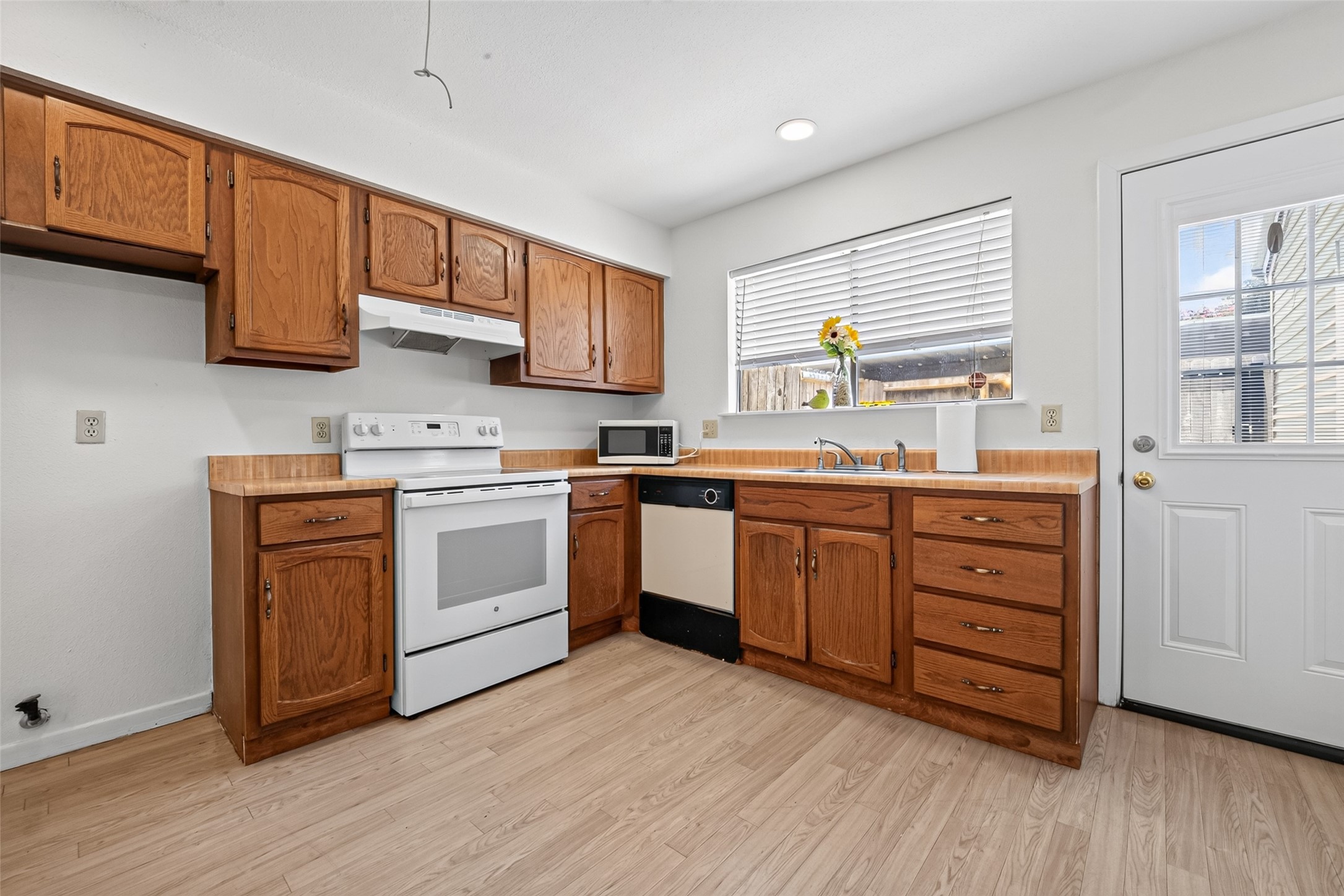 6401 Deihl Road, Unit 902 Houston, TX 77092 - Photo 9 of 35 Bright and inviting kitchen with charming wood cabinetry and easy access to the back patio through the convenient exit door on the right.