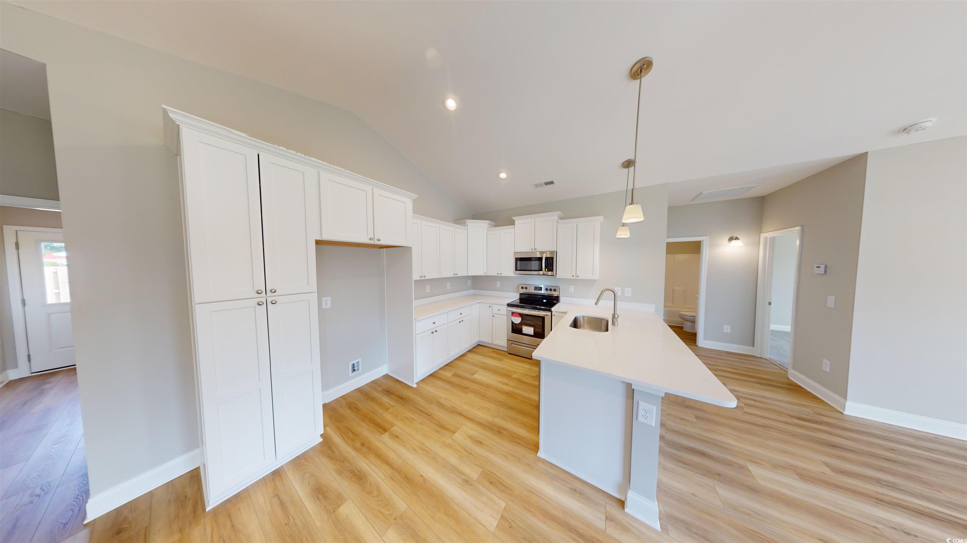 1044 Moen Loop, Unit LOT 12 Conway, SC 29526 - Photo 2 of 16 Kitchen featuring white cabinets, appliances with stainless steel finishes, vaulted ceiling, pendant lighting, and light wood-style flooring