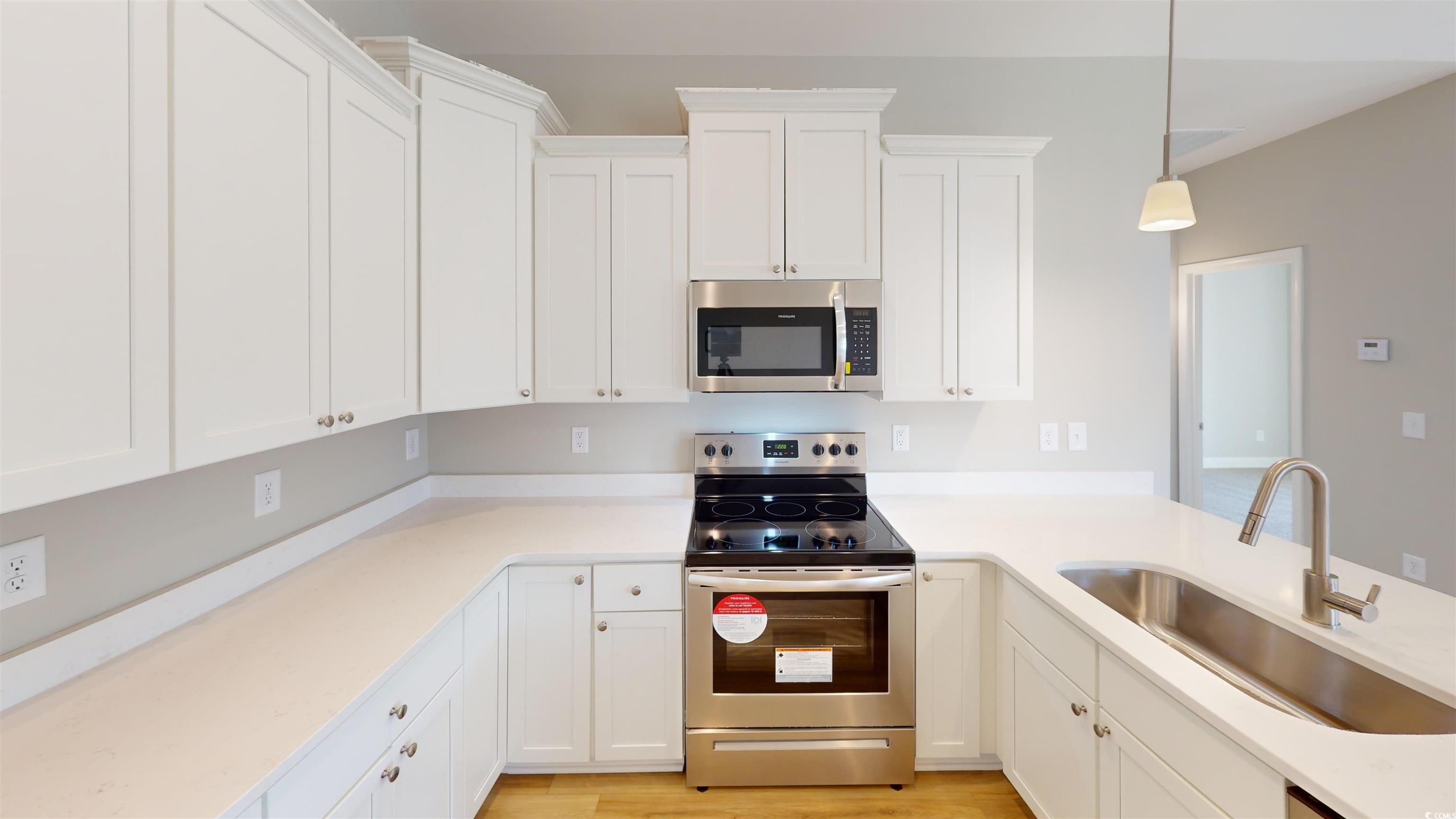 1044 Moen Loop, Unit LOT 12 Conway, SC 29526 - Photo 4 of 16 Kitchen featuring stainless steel appliances, white cabinetry, hanging light fixtures, and light stone counters