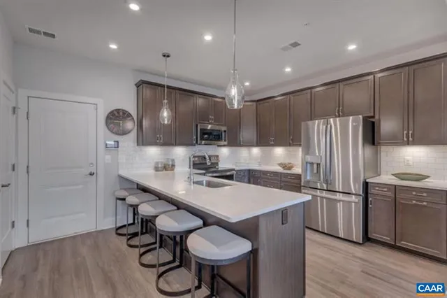 a kitchen with a table chairs refrigerator and microwave