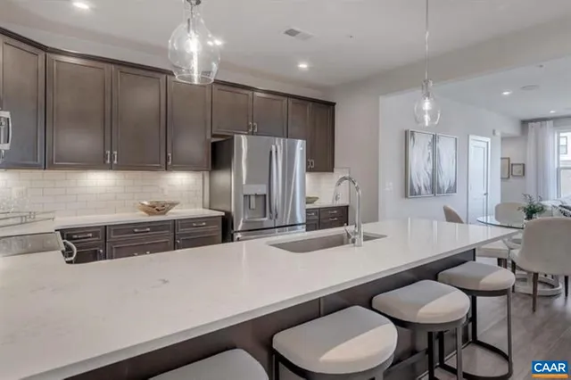 a kitchen with stainless steel appliances a sink a table and chairs