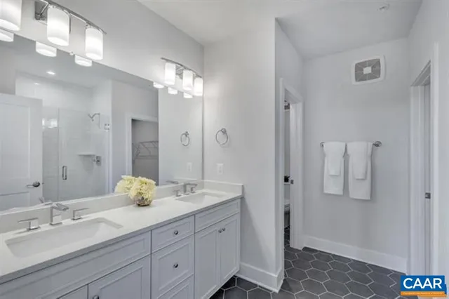 a bathroom with a double vanity sink shower and a mirror