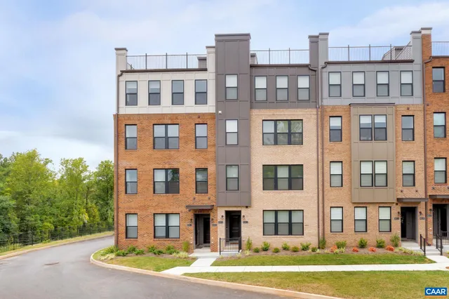 a front view of a residential apartment building with a yard