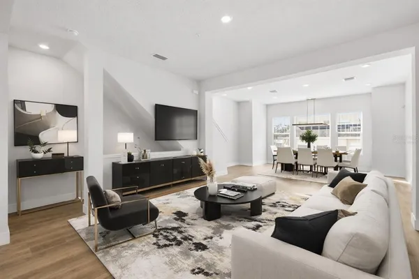 a living room with furniture wooden floor and a flat screen tv