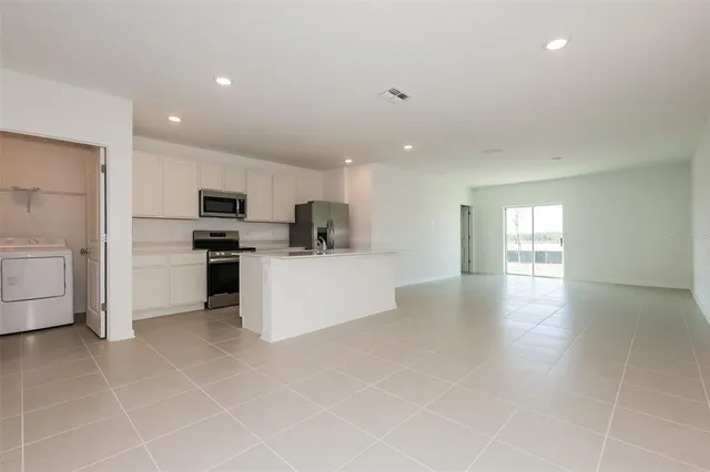 a view of kitchen with cabinets and refrigerator