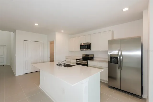 a kitchen with stainless steel appliances a refrigerator sink and stove