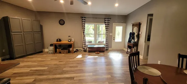 a living room with furniture a large window and wooden floor