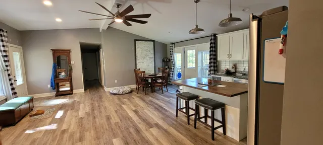a view of a livingroom with furniture a ceiling fan and front door
