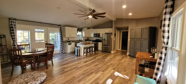 a kitchen with stainless steel appliances a dining table chairs stove and refrigerator