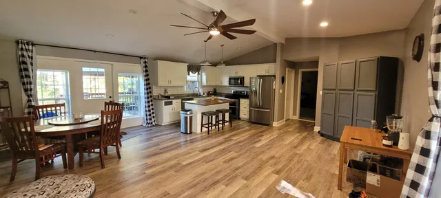 a kitchen with stainless steel appliances a dining table chairs stove and refrigerator