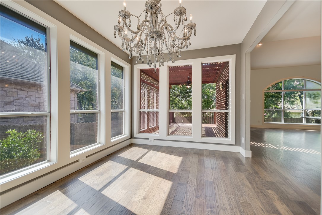 3513 Grimes Ranch Road Austin, TX 78732 - Photo 9 of 32 Unfurnished dining area featuring healthy amount of natural light, a chandelier, wood finished floors, and baseboards