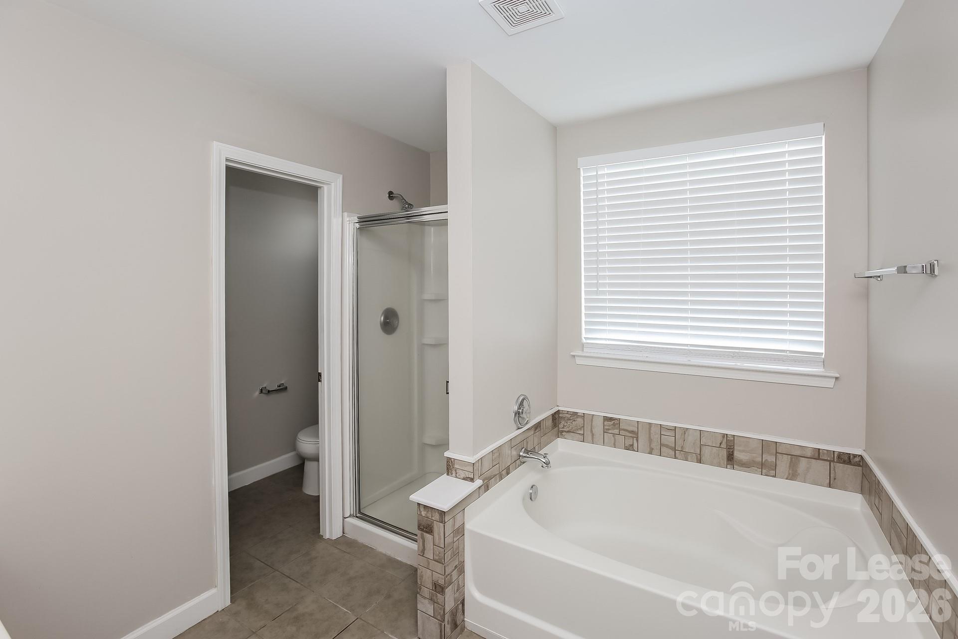 8812 Cornwall Street Locust, NC 28097 - Photo 13 of 15 a white bath tub sitting in a bathroom next to a window
