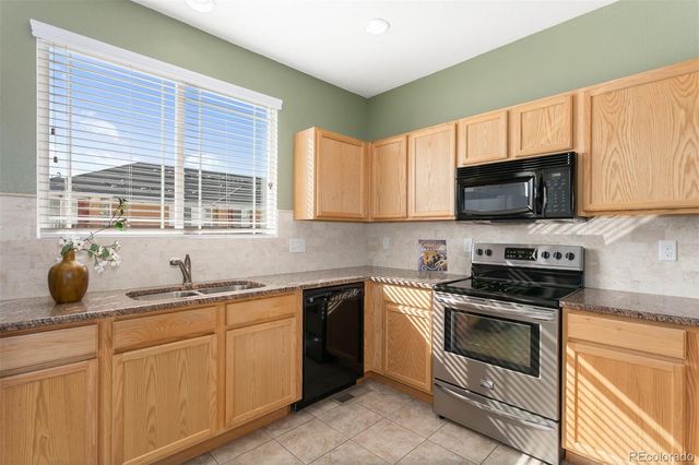 a kitchen with stainless steel appliances a stove a sink a microwave and cabinets