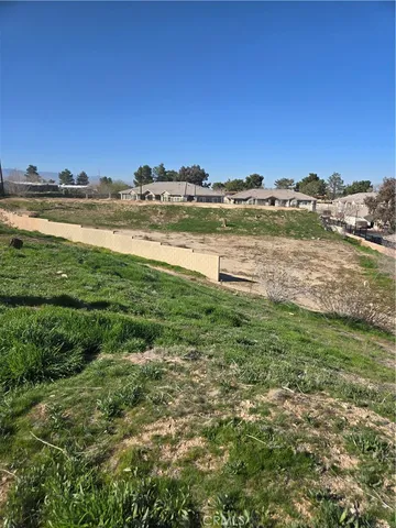 a view of a big house with a big yard and large trees