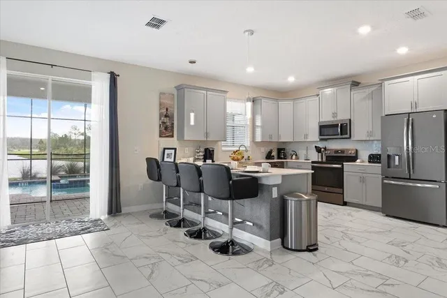 a kitchen with stainless steel appliances granite countertop a refrigerator and a stove top oven