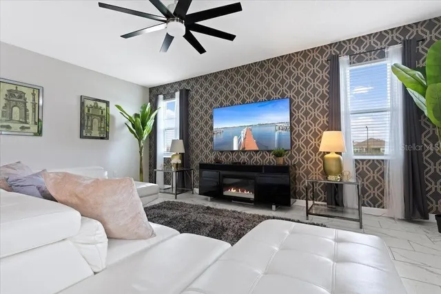 a living room with furniture a fireplace and a flat screen tv